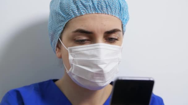스마트폰으로 마스크를 쓴 슬픈 의사나 간호사 — 비디오