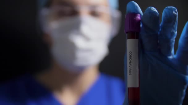 Médico sosteniendo vaso de precipitados con análisis de sangre de coronavirus — Vídeos de Stock
