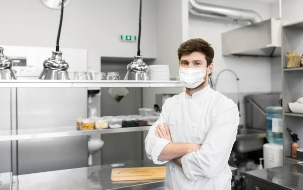Chef masculino con mascarilla en la cocina del restaurante —  Fotos de Stock