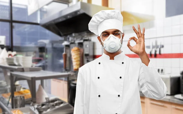 Szef kuchni w respiratorze pokazując znak ok w kuchni — Zdjęcie stockowe