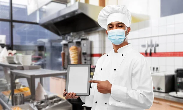 Mannelijke chef-kok in het gezicht masker met tablet pc in de keuken — Stockfoto