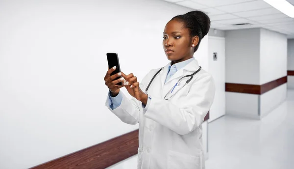 Afrikaans amerikaanse vrouwelijke arts met smartphone — Stockfoto
