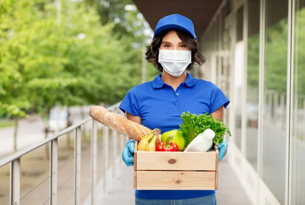 delivery woman in mask with food in box outdoors