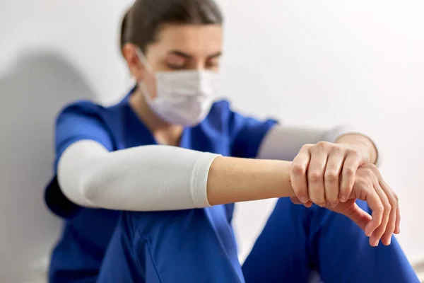 Грустный врач или медсестра в защитной маске — стоковое фото