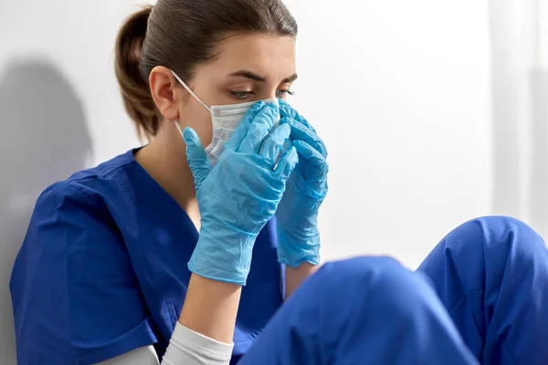 Triste médico o enfermera con mascarilla protectora — Foto de Stock