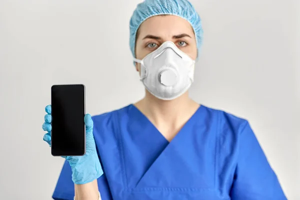 Arzt mit Brille und Mundschutz mit Smartphone — Stockfoto