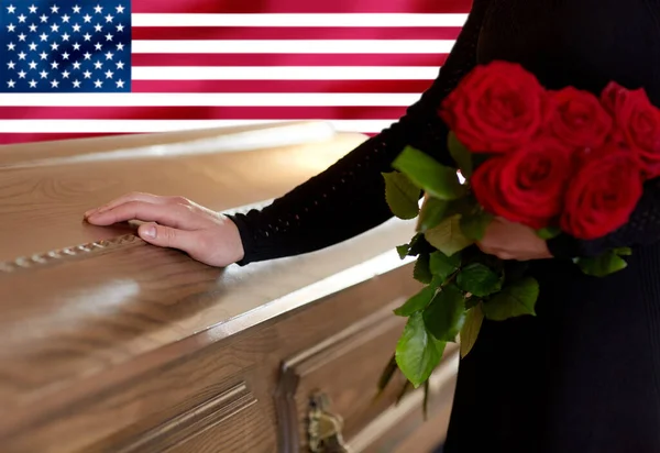 Nő vörös rózsa és koporsó felett amerikai zászló Stock Fotó