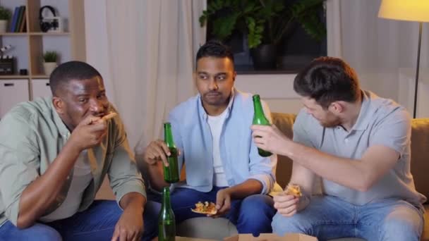 Feliz macho amigos con cerveza comer pizza en casa — Vídeo de stock