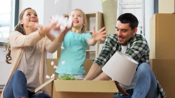 Glückliche Familie spielt mit Schaumstoff-Erdnüssen im neuen Zuhause — Stockvideo