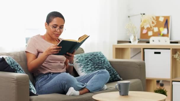 Mujer afroamericana leyendo libro en casa — Vídeos de Stock