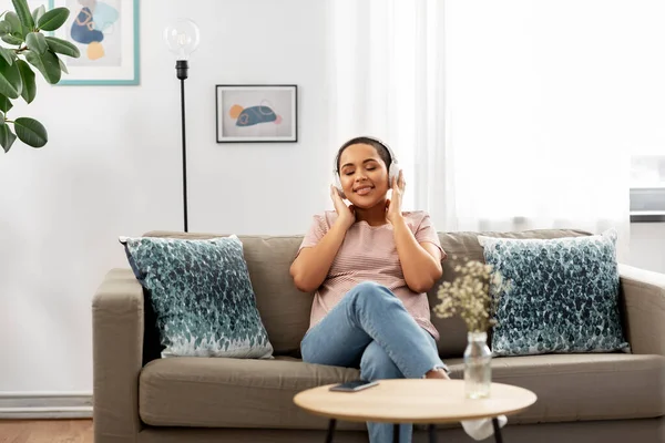 Mujer con auriculares escuchando música en casa — Foto de Stock