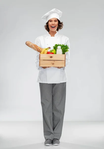 Szczęśliwy uśmiech kobieta szef kuchni z jedzeniem w drewnianym pudełku — Zdjęcie stockowe