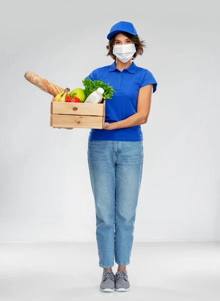 Mujer de entrega en mascarilla con comida en caja —  Fotos de Stock