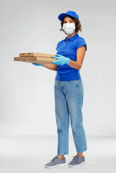 Entrega mulher em máscara facial com caixas de pizza — Fotografia de Stock
