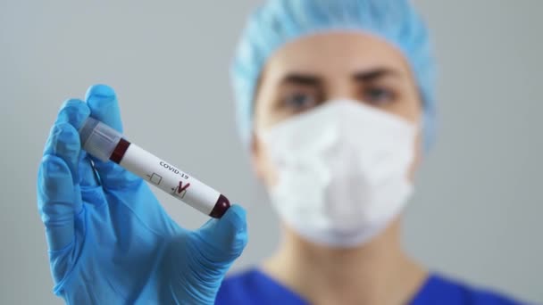 Médico sosteniendo vaso de precipitados con análisis de sangre de coronavirus — Vídeo de stock