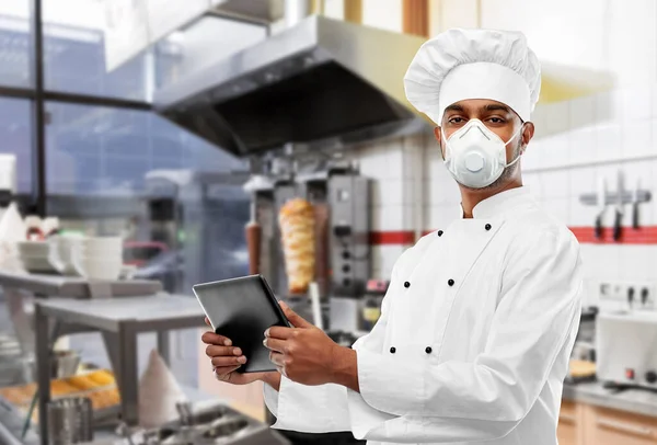 Koch in Atemschutzmaske mit Tablet-PC im Dönerladen — Stockfoto