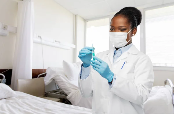 Afrikanisch-amerikanischer Arzt mit Spritze im Krankenhaus — Stockfoto