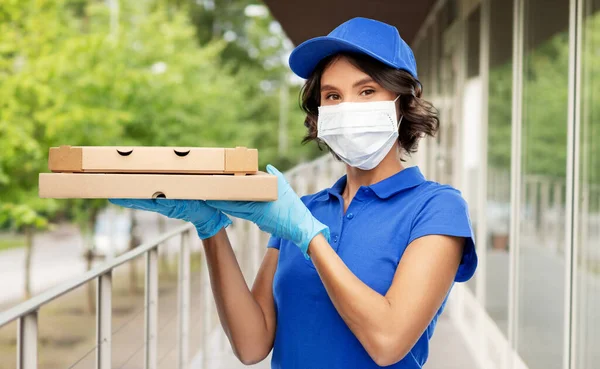 Mujer de entrega en mascarilla con cajas de pizza — Foto de Stock