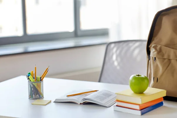 Libros, manzanas y útiles escolares en la mesa en casa — Foto de Stock