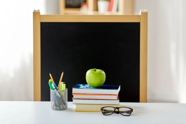 Libros, manzanas y útiles escolares en la mesa en casa — Foto de Stock