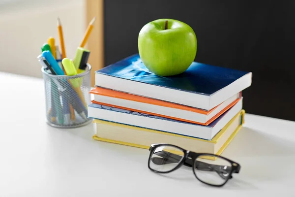 Libros, manzanas y útiles escolares en la mesa en casa — Foto de Stock