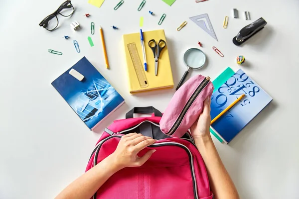 Kéz hátizsákkal, könyvekkel és iskolai felszereléssel — Stock Fotó