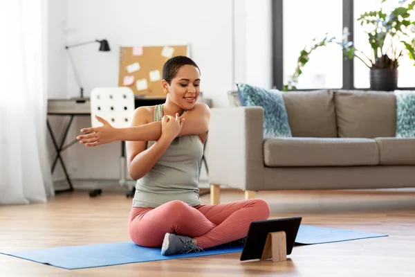 Mujer feliz con la PC tableta haciendo deportes en casa — Foto de Stock