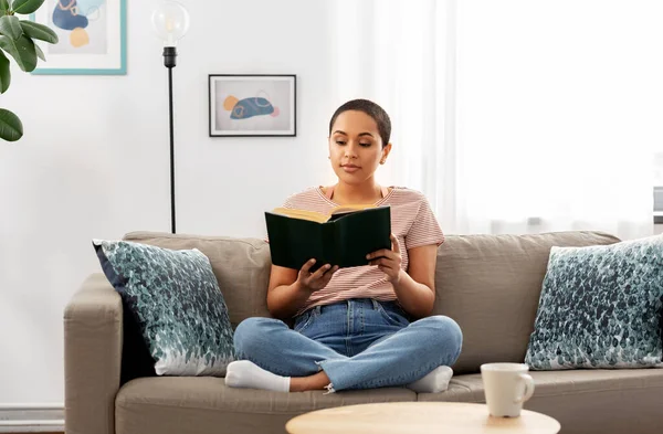 Mujer afroamericana leyendo libro en casa — Foto de Stock