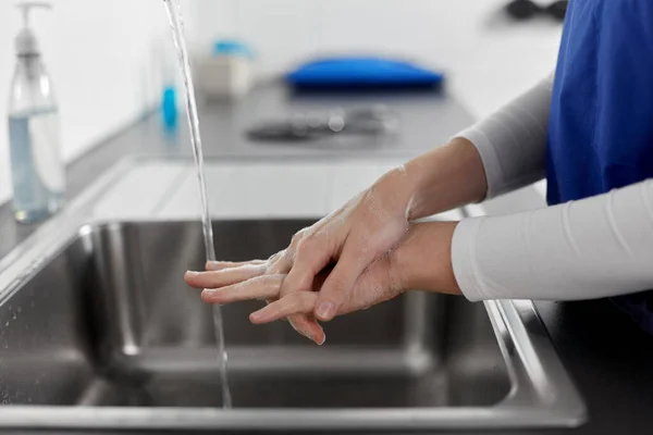 Médico ou enfermeiro lavar as mãos com sabão líquido — Fotografia de Stock