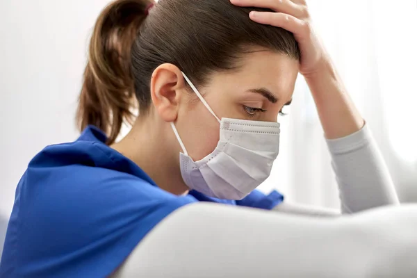 Trieste arts of verpleegkundige in het gezicht masker vasthouden aan het hoofd — Stockfoto