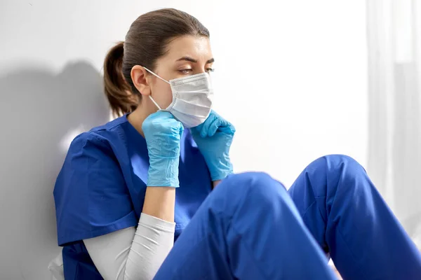 Triste médico o enfermera con mascarilla protectora — Foto de Stock