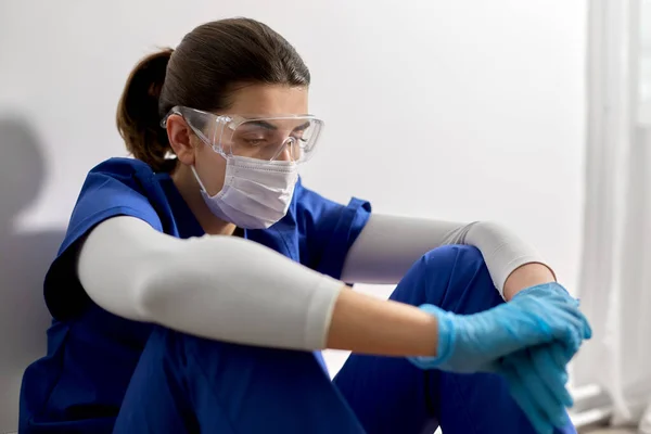 Triste médico o enfermera con gafas y mascarilla — Foto de Stock