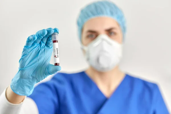 Γιατρός κρατώντας ποτήρι ζέσεως με εξέταση αίματος coronavirus — Φωτογραφία Αρχείου