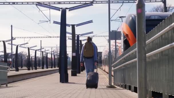 Mujer con bolsa caminando a lo largo de la estación de tren — Vídeos de Stock