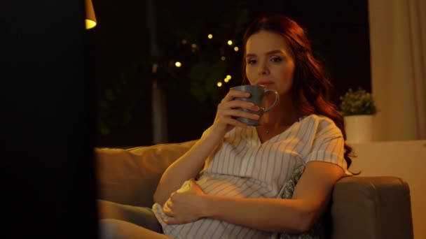 Hamile kadın televizyon izliyor ve çay içiyor. — Stok video