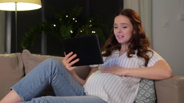 Glad gravid kvinna med tablett dator hemma — Stockvideo