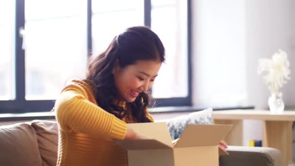 Feliz asiático joven mujer con paquete caja en casa — Vídeo de stock