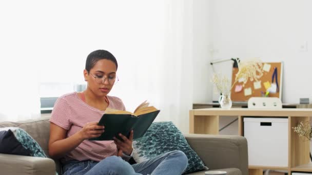 Αφροαμερικανή γυναίκα διαβάζει βιβλία στο σπίτι — Αρχείο Βίντεο