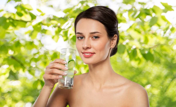 Frau trinkt Wasser mit Gurke und Eis — Stockfoto