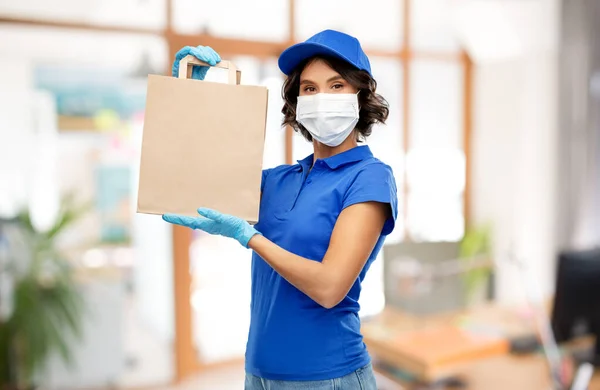 delivery woman in mask with food in bag at office