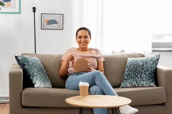 African woman eating food with chopsticks at home — Stock Photo, Image