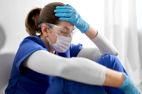 Trauriger Arzt oder Krankenschwester mit Mundschutz am Kopf — Stockfoto
