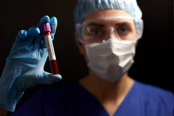 Médico segurando copo com coronavírus teste de sangue — Fotografia de Stock