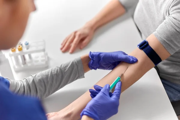 Lékař odebírající krev k vyšetření z ruky pacientů — Stock fotografie