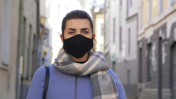 Mujer en máscara facial con signo de riesgo biológico en la ciudad — Vídeo de stock