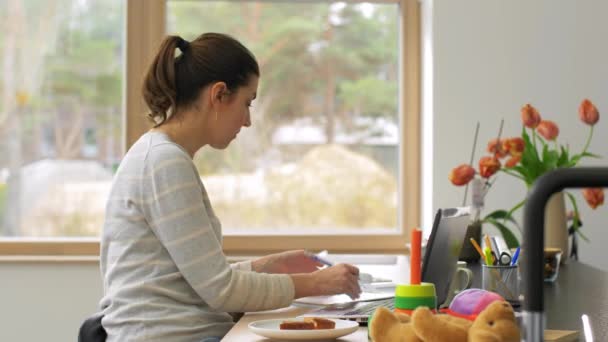 Молодая женщина с ноутбуком работает в домашнем офисе — стоковое видео