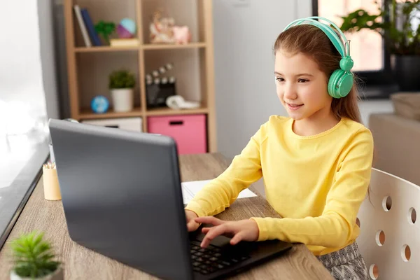 Chica en auriculares con ordenador portátil en casa —  Fotos de Stock
