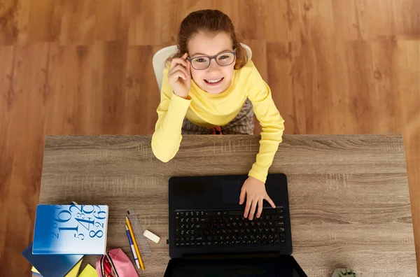 Chica estudiante sonriente escribiendo en el ordenador portátil en casa — Foto de Stock