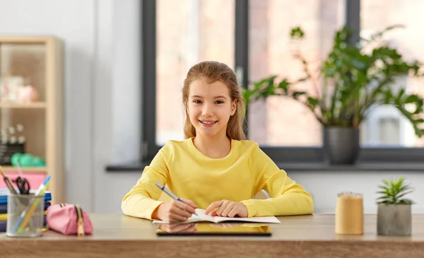 Student girl writing to notebook at home — Stock Photo, Image