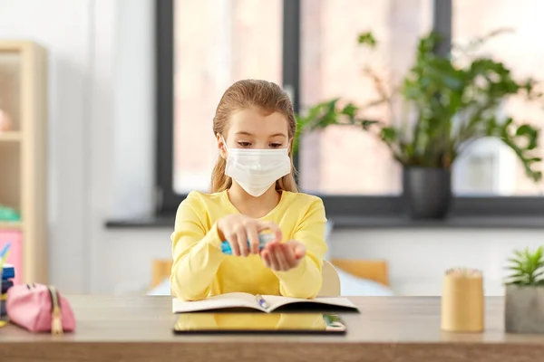 Sick girl in mask with hand sanitizer at home — Stock Photo, Image